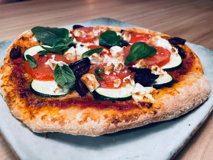 Pizza met courgette, tomaten, basilicum en mozzarella