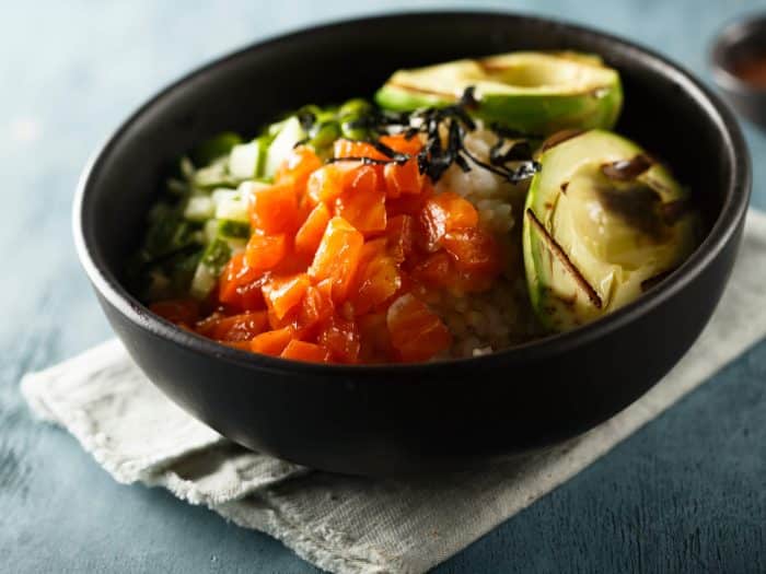 Pokebowl met rijst, kip, avocado, zalm en komkommer